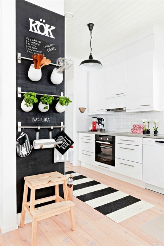 a chalkboard wall with metal railings that allow attaching pots, holders and hooks to them is a lovely dea