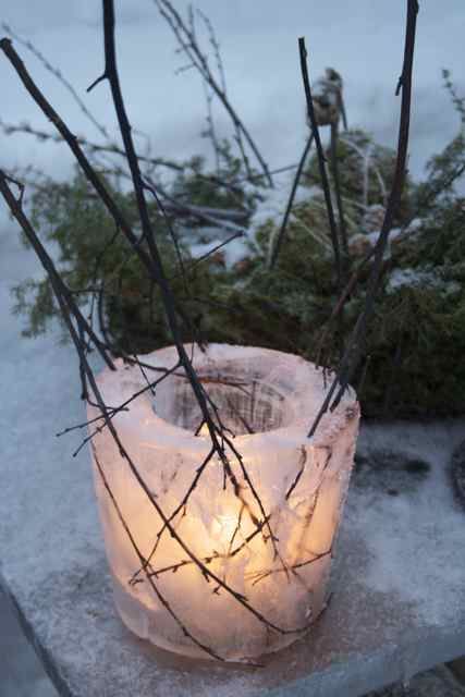 a simple ice luminarie with twigs in it is a cool rustic decor idea for a garden or a porch and it's pretty easy to make