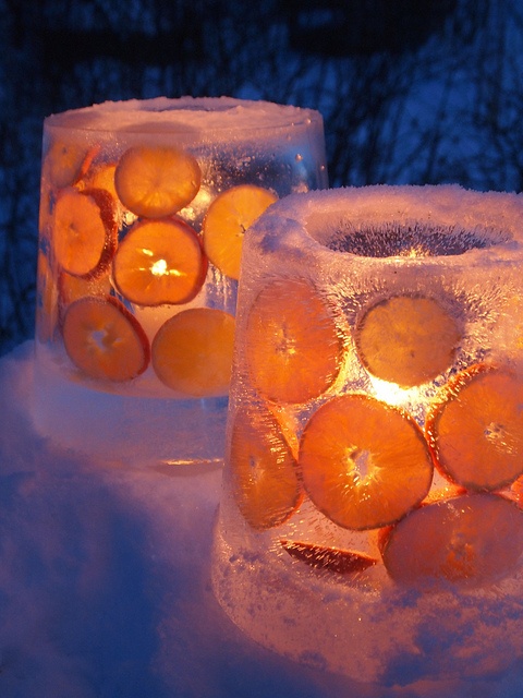 ice luminaries with citrus slices add a catchy touch and a warm glow to the space making it softer and cozier