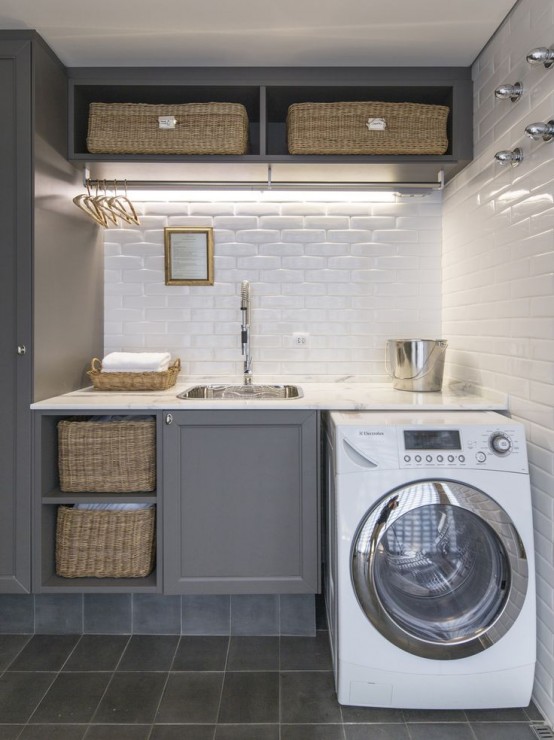 a stylish modern farmhouse with shaker style cabinets, white subway tiles, lights, a washing machine and baskets for storage