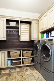 a modern farmhouse laundry space with light-colored cabinets, baskets, open shelves and a washing machine and a dryer