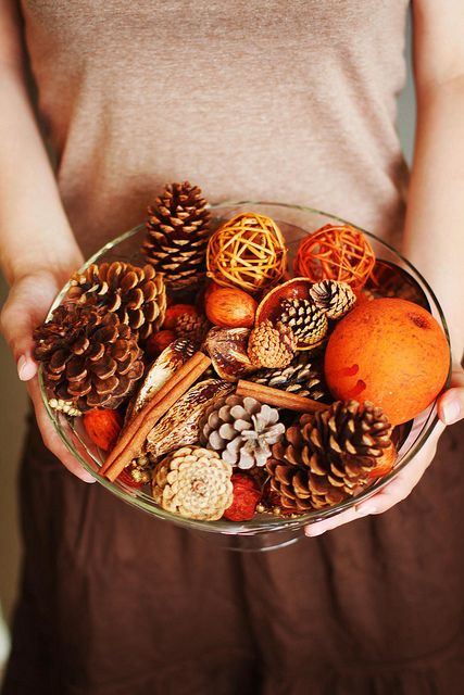 a bowl with pinecones, cinnamon sticks, yarn balls and nuts and citrus will not only add to the decor but also will bring a nice natural aroma