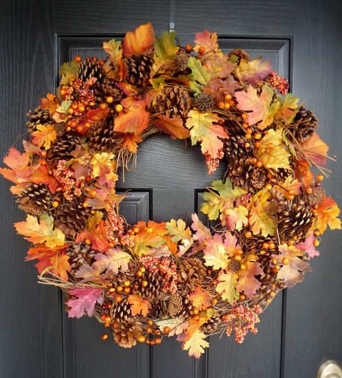 a bright fall wreath of pinecones, bold fall leaves berries is a stylish and timeless front door decoration
