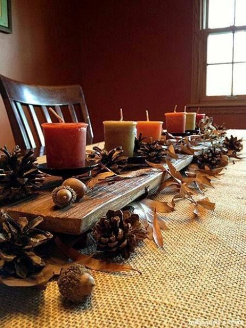 a fall centerpiece of pinecones, fall leaves, nuts and acorns and fall-colored candles is a very natural autumn decoration