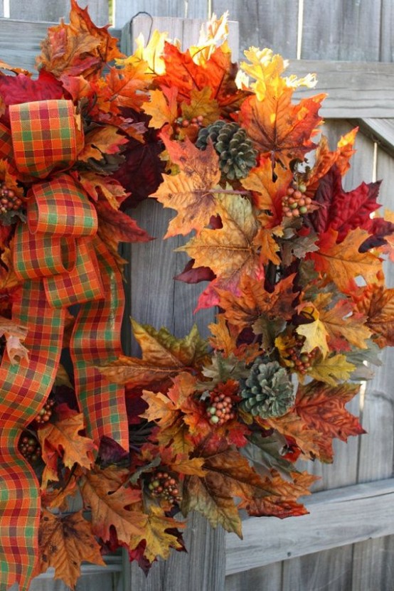 a bold fall wreath of faux leaves, berries, pinecones and accented with a bright plaid ribbon bow for your front door