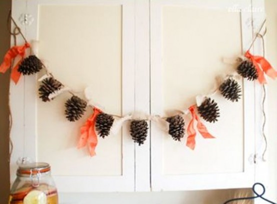 a fall pinecone garland with bright orange fabric touches will be a nice decoration for your space in the fall