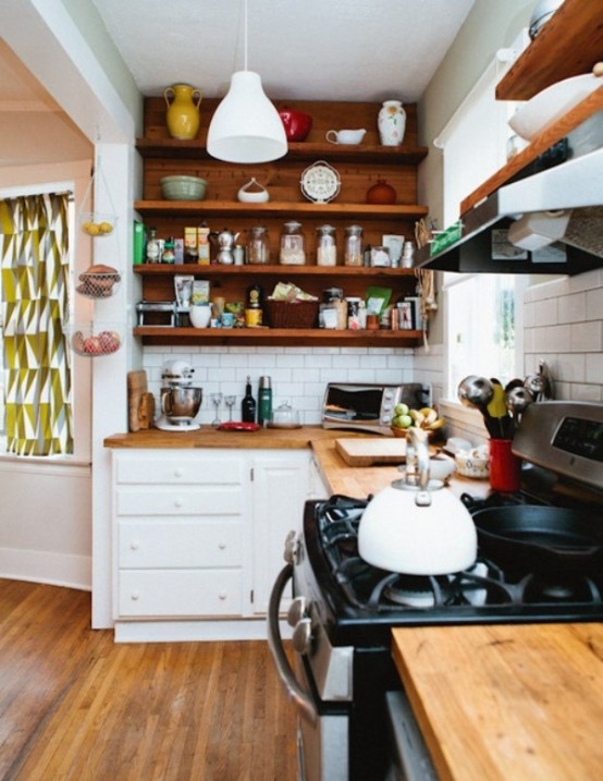 a small modern kitchen done in white and rich stained wood, with lots of open shelves and white tiles