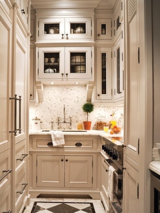 a small off-white vintage-inspired kitchen with lot sof storage space, a tile backsplash and additional lights for comfortable cooking
