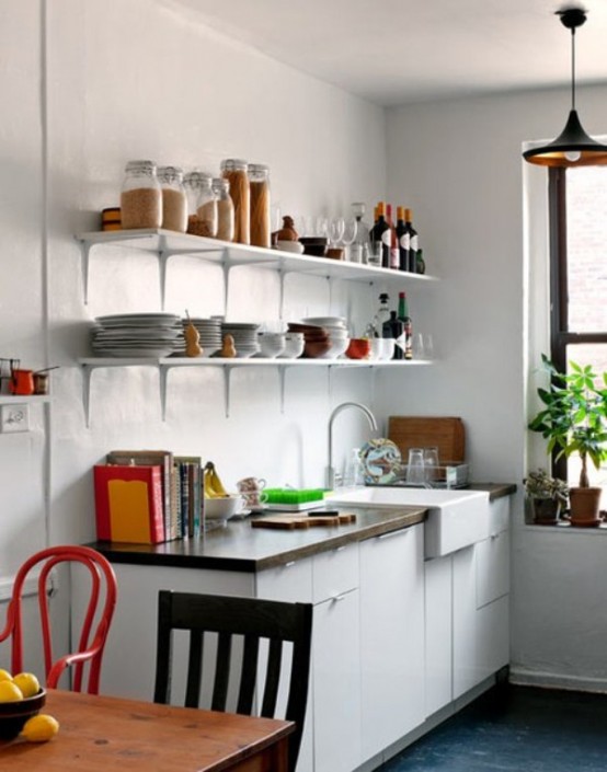 a small contemporary kitchen with white cabinets, open shelving, a dining space with mismatching chairs