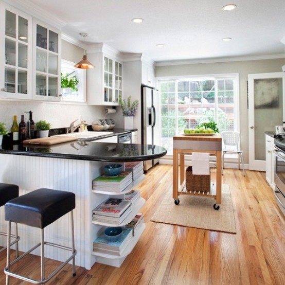 a small modern farmhouse kitchen done with white cabinets, black countertops, leather stools and a wooden kitchen island on wheels