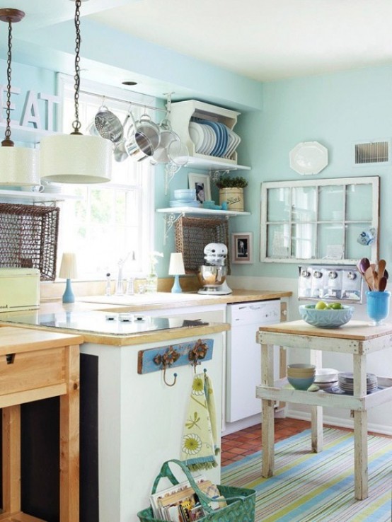 a vintage-inspired small aqua kitchen with neutral cabinets and light stained countertops, a small kitchen island, open shelves and pendant lamps