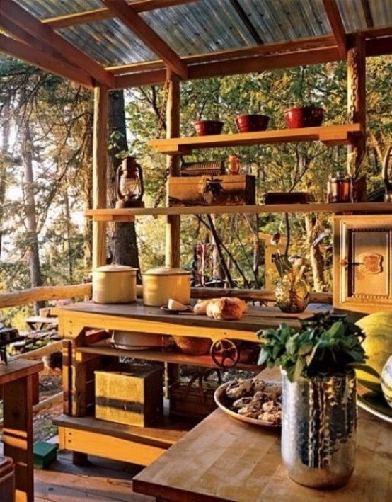 a small outdoor kitchen with wooden cabinets and open shelving to enjoy the views, touches of yellow and candle lanterns