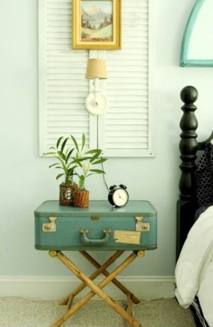 a blue vintage suitcase placed on brass folding legs gives you storage space as a bedside table and lets you fold it and take away