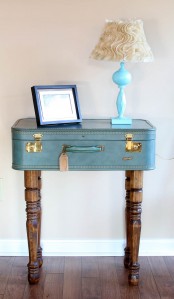 a refined side table of a vintage blue suticase on stained legs is a chic and pretty idea with a touch of color
