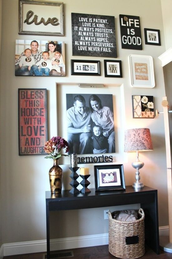 an eclectic gallery wall with various photos, signs and artworks in various frames and with additional light