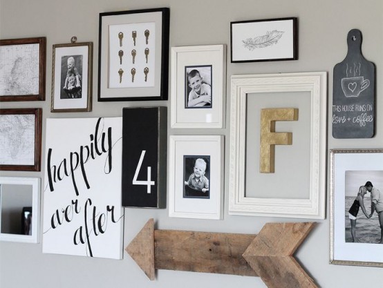 muro galería en blanco y negro, con marcos, letreros, números y una flecha de madera que no coinciden es creativa y divertida