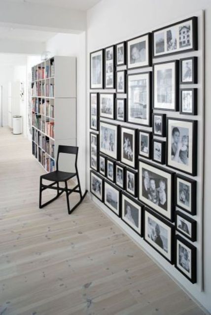 a large black and white gallery wall with black and white family photos in matching black frames is always a stylish idea