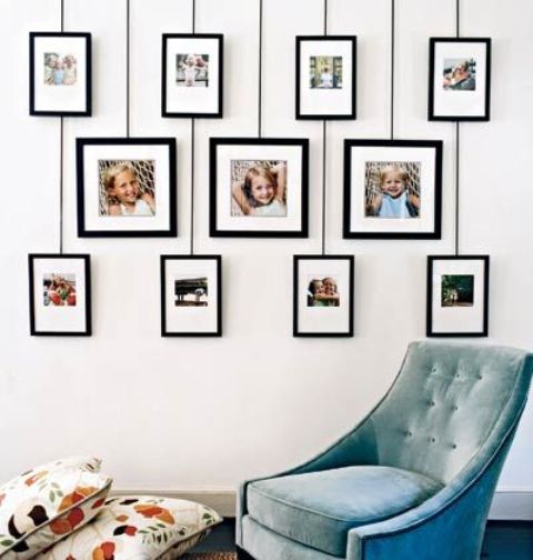 una pared de galería pegadiza con fotos familiares en tres filas con fotos más grandes y más pequeñas es una idea elegante