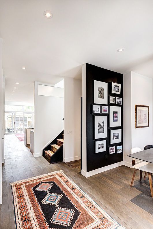 a catchy gallery wall with black and white and color photos in matching black frames that make it cohesive