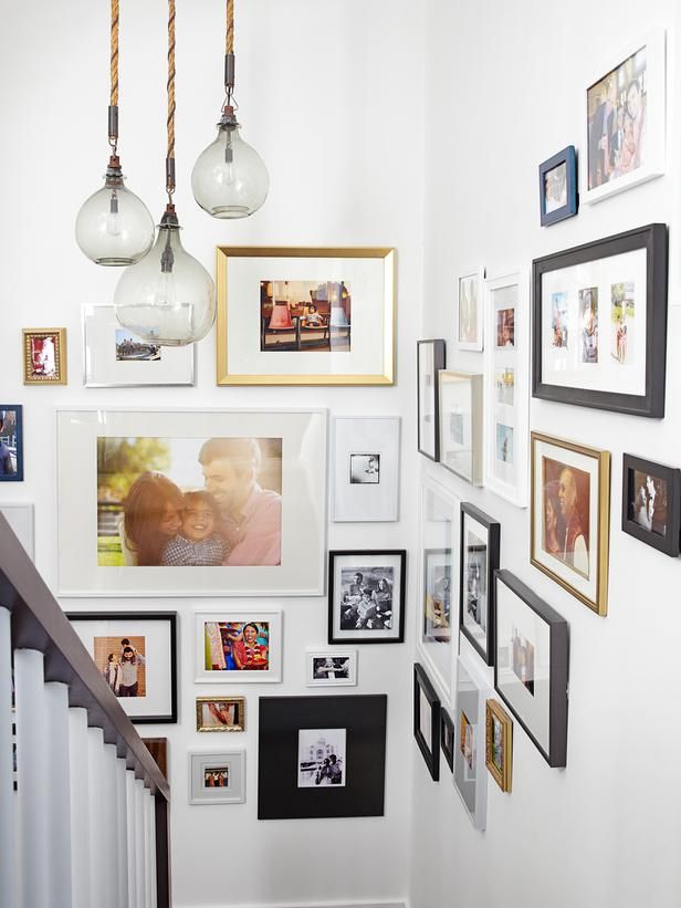 an eclectic gallery wall with color and black and white photos in mismatching frames will make going up and down more interesting