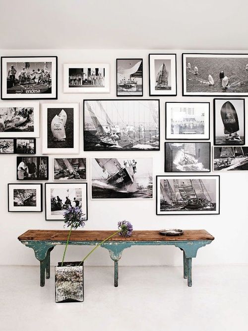 an oversized black and white gallery wall with pics in white and black frames looks chic and bold
