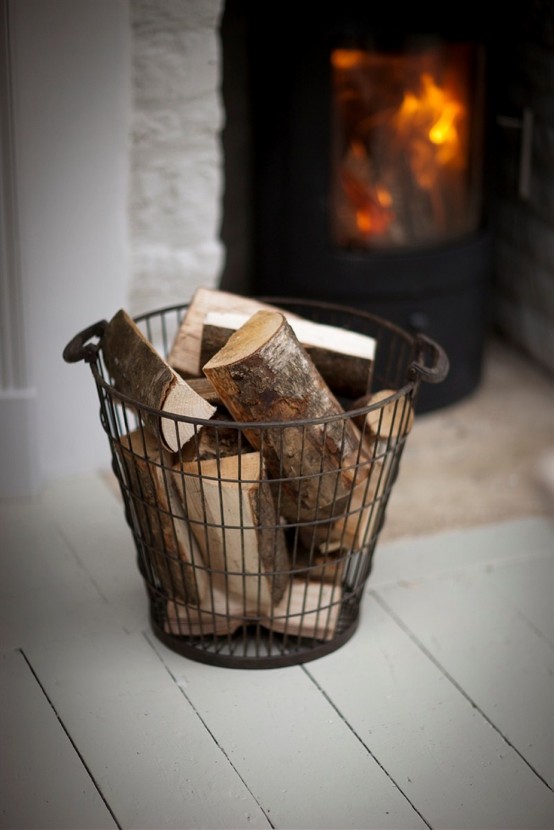 a wire basket with firewood is a cool idea to store it adding coziness and a vintage feel to the space
