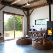 a modern and laconic fireplace and a wooden storage unit with firewood and with various objects on display for a modern and airy space