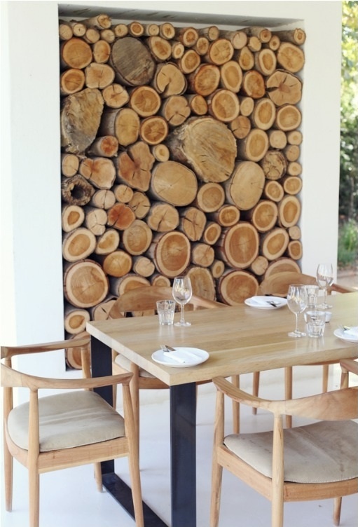 a niche with firewood as a decor feature for an outdoor dining room, to connect it to nature and make it look cozy