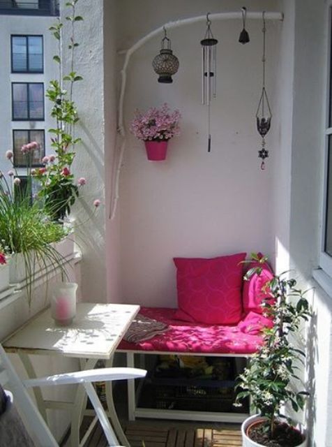 a small summer balcony in white, with bright pink and fuchsia touches, potted blooms and greenery and boho candle lanterns
