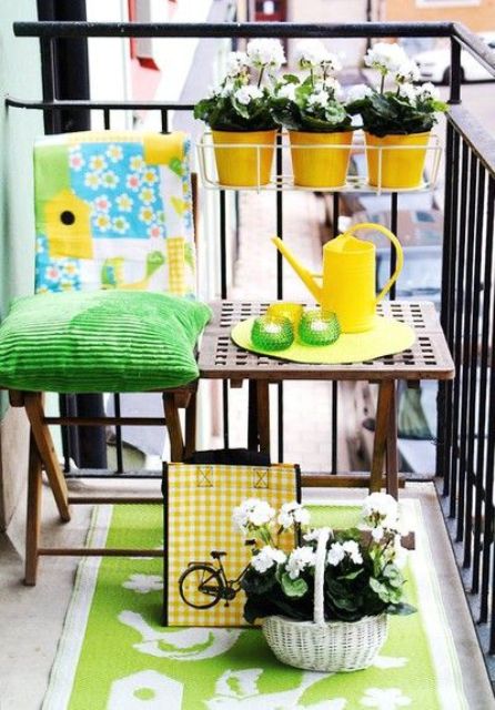 a bright and colorful summer balcony with bold green textiles, potted blooms and colorful tableware for a vivacious feel