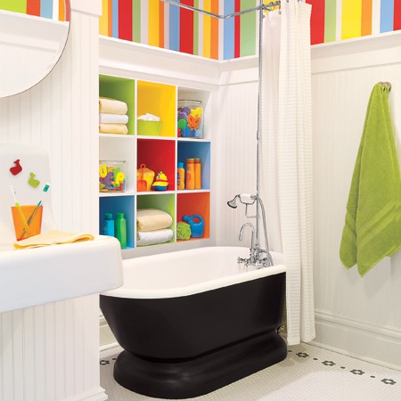 Colorful kids bathroom idea with candy-stripe wall paper and colorful shelves.