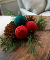 red and green patterned Christmas ornaments, evergreens and pinecones compose a great and bright Christmas decoration