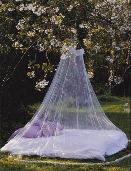 a daybed in the garden with a mosquito net that highlights it and save a person from bugs