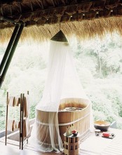 an outdoor ofuro tub protected with a mosquito net from bugs, the net also gives privacy to the person here