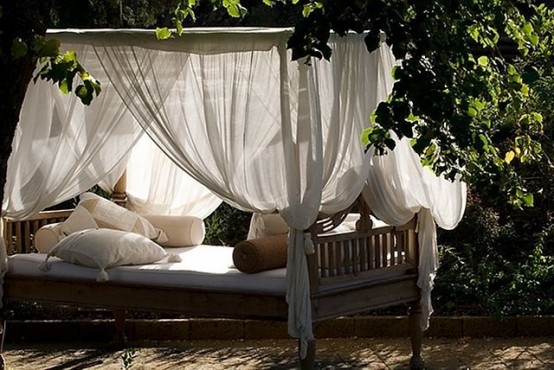 an outdoor daybed with canopy curtains and lots of pillows is a very relaxing idea to try