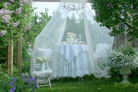 an outdoor dining space with chairs and a table plus a mosquito net over the whole space