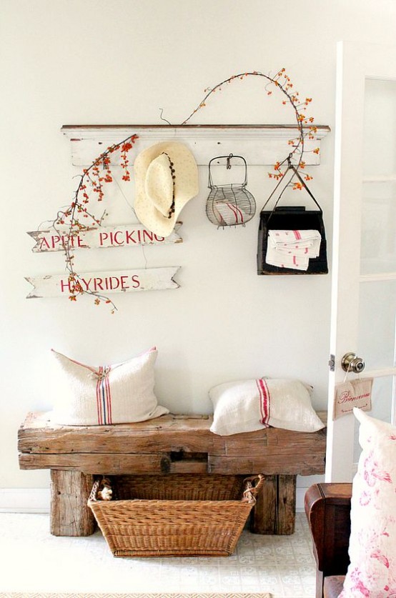 a rustic meets shabby chic entryway with a wooden bench, signs, a shelf, a basket for storage feels cozy