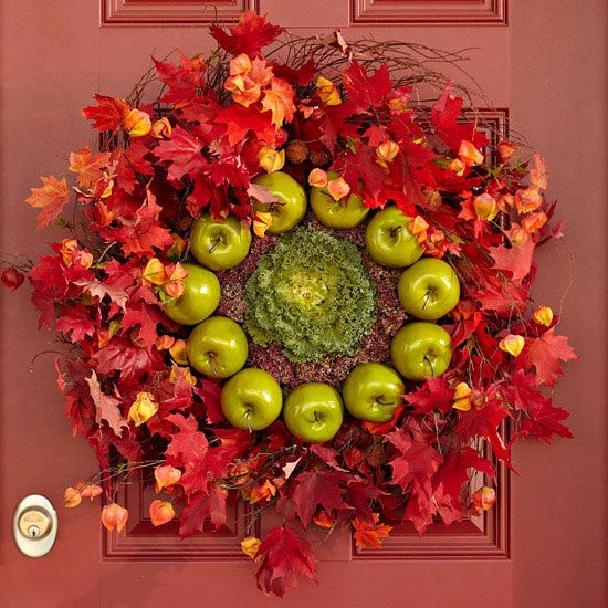 a super bold fall wreath of bright red leaves, dried blooms, cabbage and green apples is very farm-like