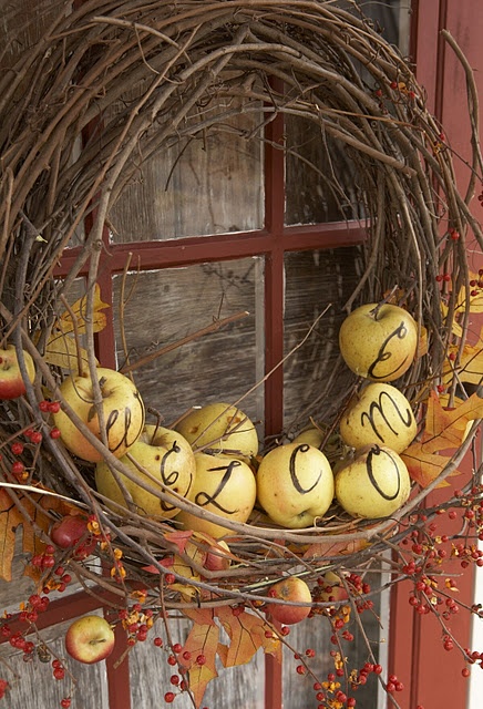 a rustic fall wreath of vine, real apples with letters, branches with berries and fall leaves is all-natural and cool