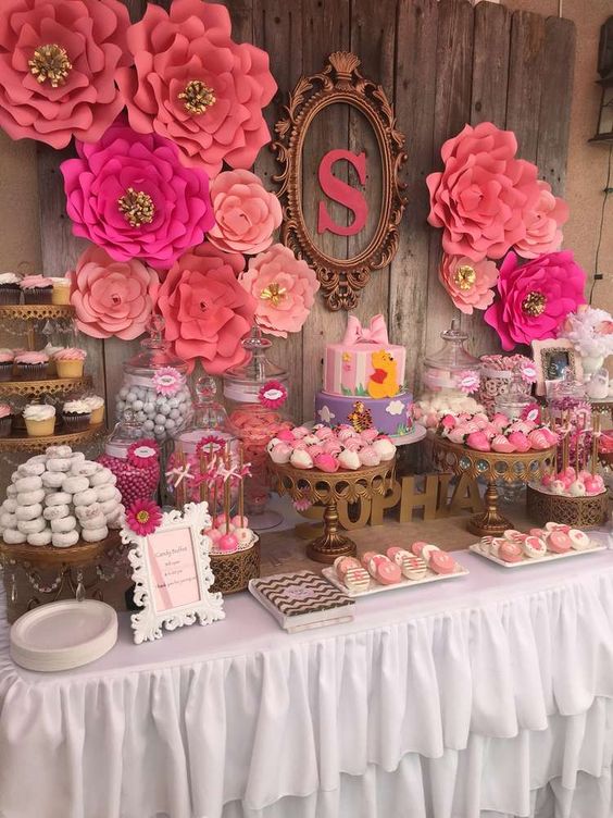 a bright pink and fuchsia dessert table with large paper flowers, touches of brass, monograms and letters