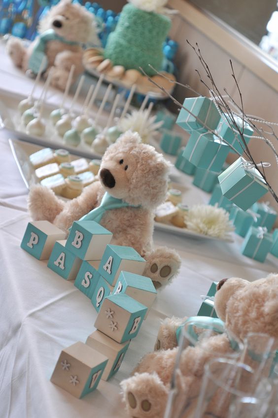 a boy's baby shower dessert table decorated in turquoise, with turquoise cubes and a funny teddy bear