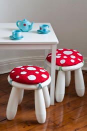 a white table and white IKEA Mammut stools spruced up with bright mushroom-inspired pillows to look whimsy