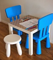 a white IKEA Mammut stool and bright plastic chairs for an art or play space for your kids