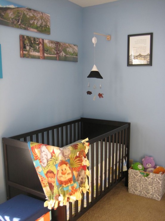 a pastel nursery with blue walls and a neutral floor plus a dark stained IKEA Sundvik crib that makes a statement