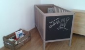 a neutral IKEA Sundvik crib is spruced up with a chalkboard side for some interactivity and creativity