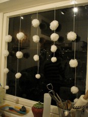 white pompoms hanging down as snowballs on the window will bring a strong winter feel indoors
