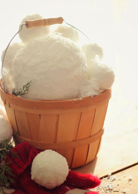 a wooden basket filled with large snowballs is a great idea for a rustic winter space, it can bring a cozy feel both indoors and outdoors