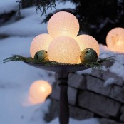 a metal bowl with lit up snowballs, bells and fir twigs is a lovely decoration for outdoors, it will bring some light