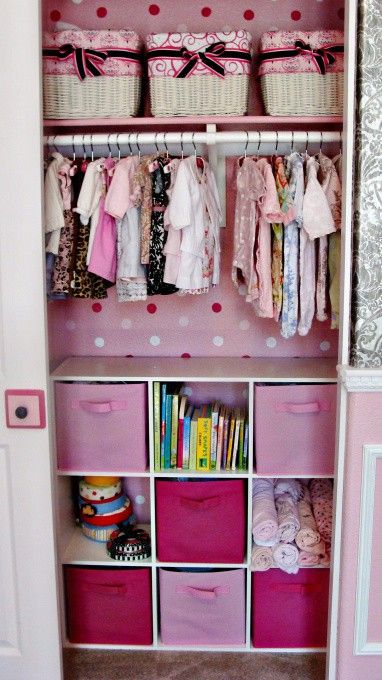 a closet with clothes hangers, basket boxes for storage and a storage unit with fabric boxes