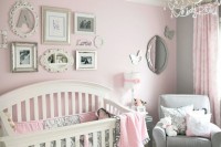 a vintage girl’s nursery with pink and grey walls, furniture and bedding, a gallery wall with vintage frames and a crystal chandelier